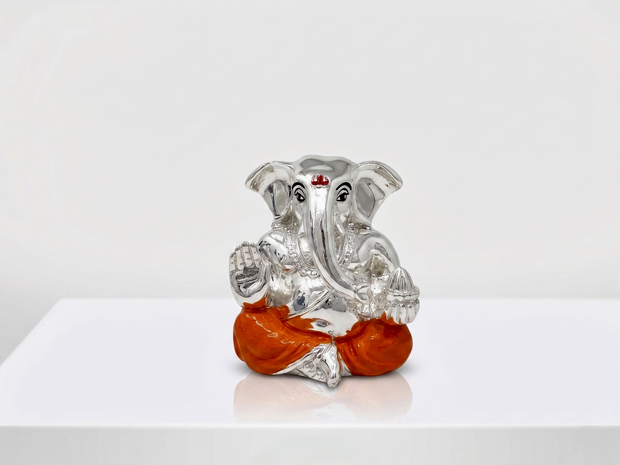 Gemini_Generated_Image_qj3oq6qj3oq6qj3o 999 Silver Coated Ganesha Idol in Orange Dhoti for Home Decor – 6.5 cm - Image 1